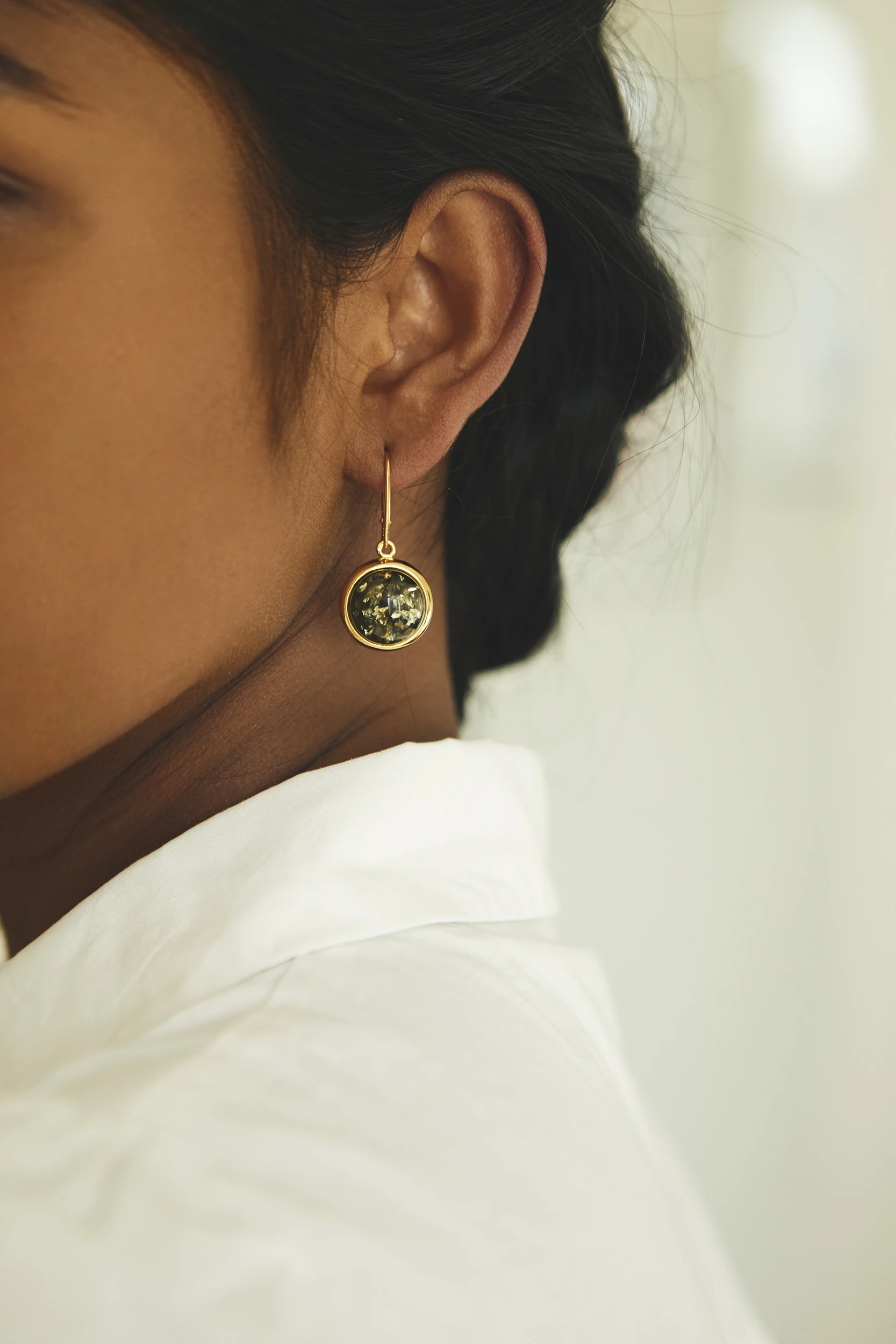 Luna örhängen i guld med grön bärnsten